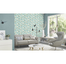 Helles Wohnzimmer mit Sofa, Sessel, Tisch und gemusterter Tapete