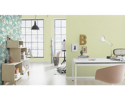 Helles Arbeitszimmer mit Schreibtisch, Bücherregal und floraler Tapete