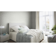 Schlafzimmer mit Bett, Nachttisch und gemusterter Tapete