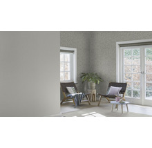 Heller Raum mit gemusterter Tapete, zwei Holzstühlen und einem kleinen Tisch