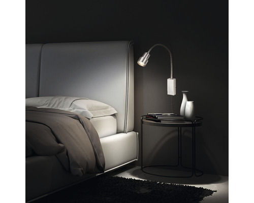 Schlafzimmer mit Bett, Nachttisch und Wandleuchte
