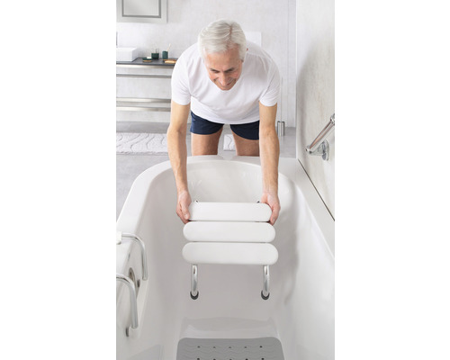 Un homme place un siège de bain dans une baignoire pour plus de confort et de sécurité