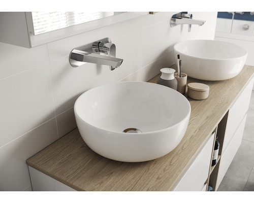 Deux vasques à poser sur un meuble-lavabo avec robinets sur un mur de salle de bains.