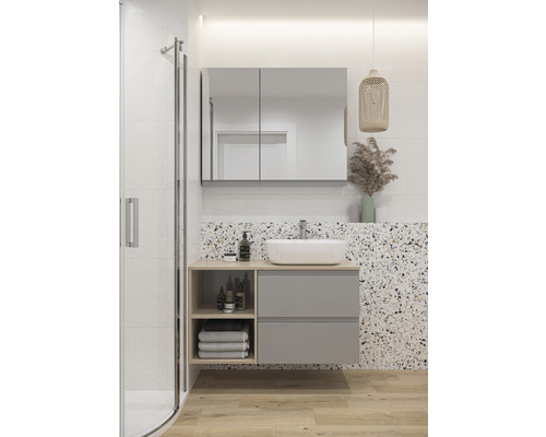 Salle de bain moderne avec lavabo, miroir, armoire et douche.