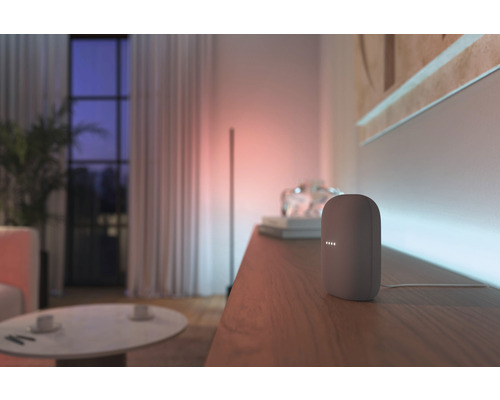 Haut-parleur intelligent sur un meuble en bois dans un salon