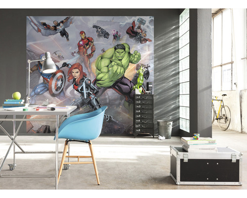 Une pièce avec un papier peint photo avec des personnages de bande dessinée, un bureau, une chaise et un conteneur à roulettes.