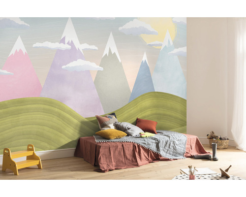 Kinderzimmer mit Bergmotivtapete, Bett und Spielsachen für eine helle und freundliche Atmosphäre