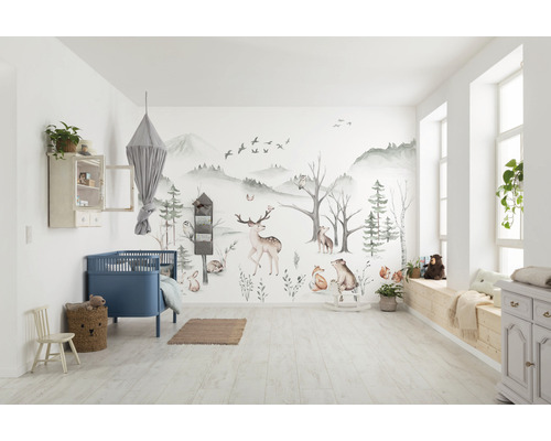 Chambre d''enfant lumineuse avec papier peint forêt, lit à barreaux bleu et meubles en bois