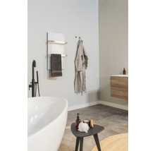 Salle de bain avec baignoire, sèche-serviettes, peignoir et lavabo