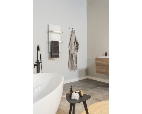 Salle de bain avec baignoire, sèche-serviettes, peignoir et lavabo