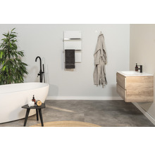 Salle de bain moderne avec baignoire îlot, sèche-serviettes et meuble-lavabo