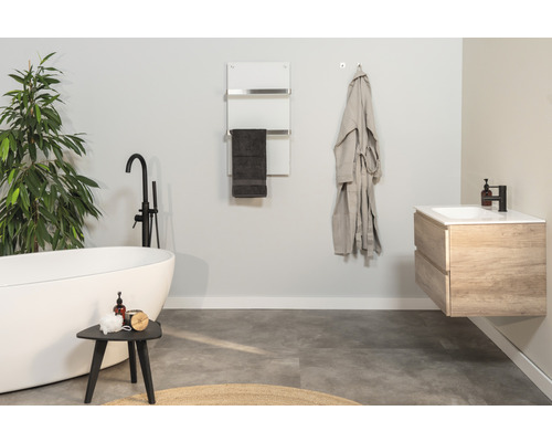 Salle de bain moderne avec baignoire îlot, sèche-serviettes et meuble-lavabo