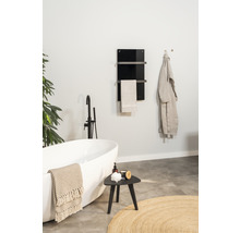 Salle de bain moderne avec baignoire îlot, sèche-serviettes et décorations pour une ambiance relaxante