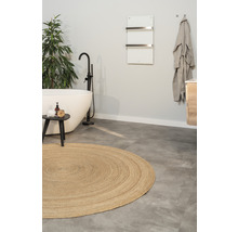 Vue d''une salle de bains avec baignoire, tapis rond et sèche-serviettes