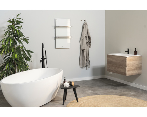 Salle de bains lumineuse avec baignoire îlot, meuble sous-lavabo et sèche-serviettes