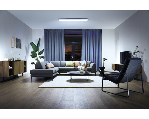 Modernes Wohnzimmer mit Ecksofa, Teppich und Deckenleuchte