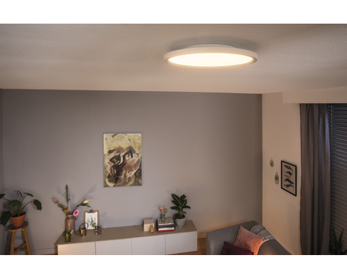 Salon avec plafonnier, commode et décoration