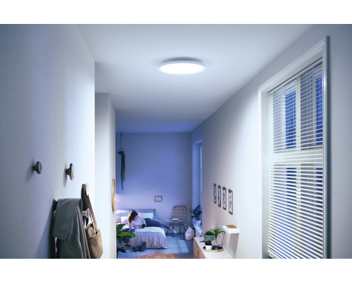 Couloir avec plafonnier, patères et vue sur la chambre à coucher