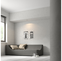 Helles Wohnzimmer mit Couch, zwei Kissen und Wandbildern