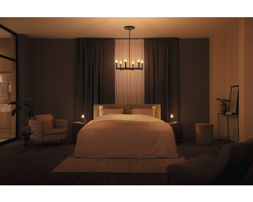 Chambre à coucher avec lit, tables de chevet, chaise, fauteuil, plafonnier et décoration