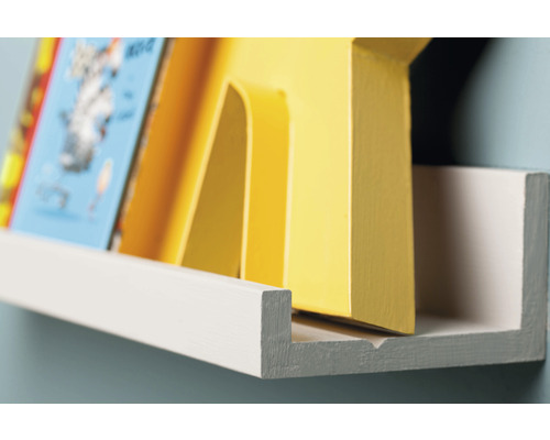 Gros plan d''une étagère murale blanche avec des livres pour enfants et un élément décoratif jaune