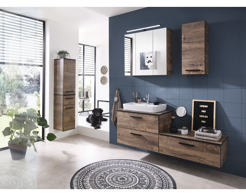 Salle de bain moderne avec lavabo, armoire de toilette et armoire haute à l''aspect bois, ainsi qu''un tapis rond
