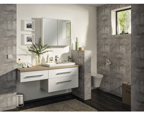 Salle de bains lumineuse avec meuble sous-lavabo, armoire de toilette et carrelage mural aspect pierre