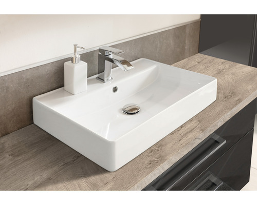 Lavabo en céramique avec robinet et distributeur de savon sur meuble sous-lavabo