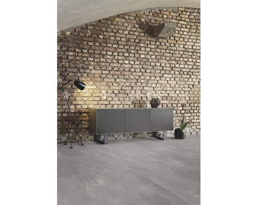 Salon avec buffet, lampadaire et mur en briques