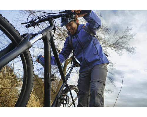 Mann mit Mountainbike im Gelände
