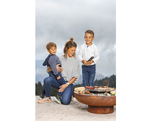 Familie grilliert mit einer Feuerstelle im Freien