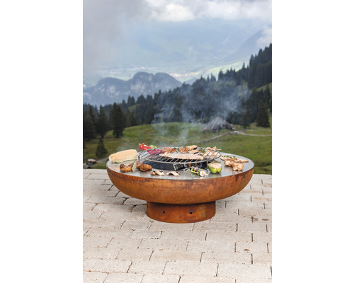 Runder Grill mit Speisen und Landschaft im Hintergrund