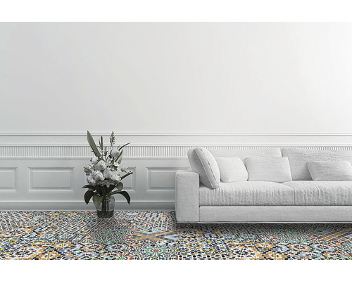 Salon avec carrelage à motifs, un canapé et un vase de fleurs