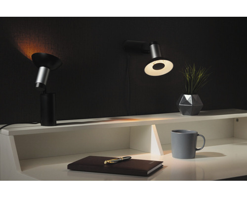 Scène de bureau avec deux lampes, un carnet, un stylo, une tasse et une plante