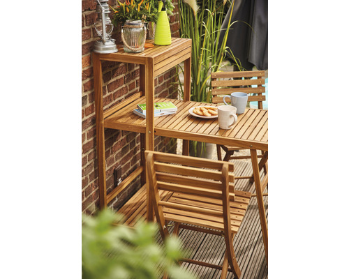 Scène de jardin avec table en bois, chaises et étagère contre un mur de briques