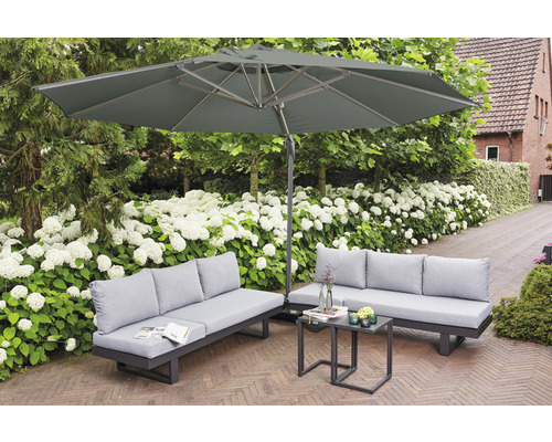Gartenszene mit Sonnenschirm, Sofas und Tisch auf einer Terrasse