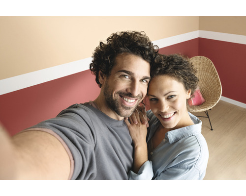 Couple souriant devant un mur avec un accent de couleur