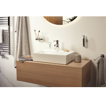 Salle de bains lumineuse avec meuble sous-lavabo, lavabo, robinet et accessoires
