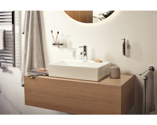 Salle de bains lumineuse avec meuble sous-lavabo, lavabo, robinet et accessoires