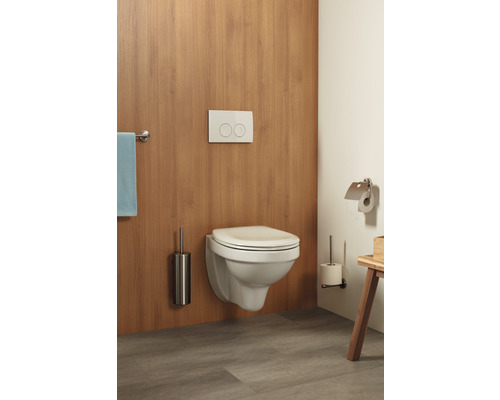 WC suspendu avec plaque de commande, brosse de toilette et porte-papier toilette dans une salle de bains.