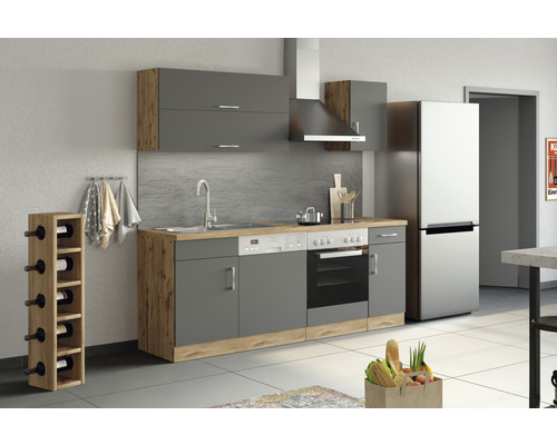 Cuisine complète avec éléments hauts, évier, cuisinière, hotte aspirante et réfrigérateur.