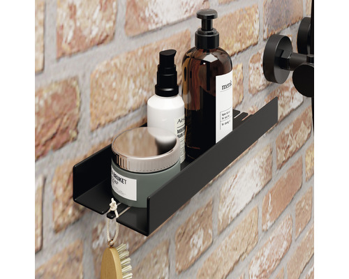 Schwarzes Wandregal im Badezimmer mit Kosmetikprodukten auf Ziegelwand