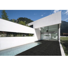 Moderne Architektur eines weißen Hauses mit großer Glasfront, Pool und einer dunklen Fliesenterrasse im Außenbereich.