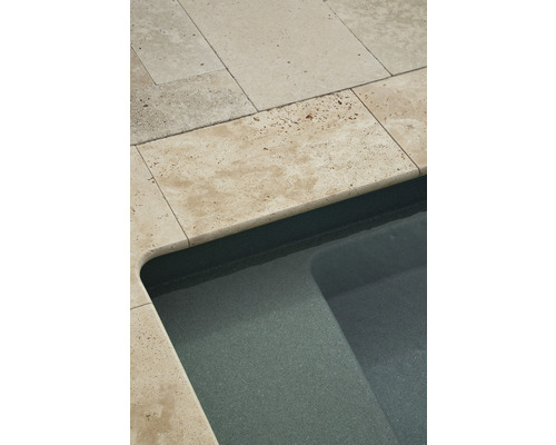 Gros plan d''une piscine avec bordure en travertin
