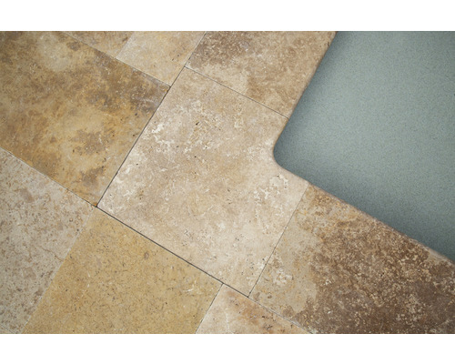 Carrelage en travertin posé à côté du bord d''un bassin