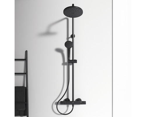 Robinet de douche noir avec douche de tête et douchette à main monté sur un mur.