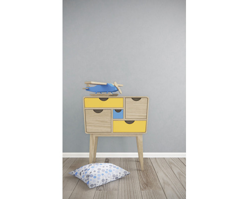 Table de chevet avec tiroirs, avion jouet et coussin