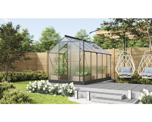 Serre de jardin avec plantes, clôture en bois et fauteuil suspendu