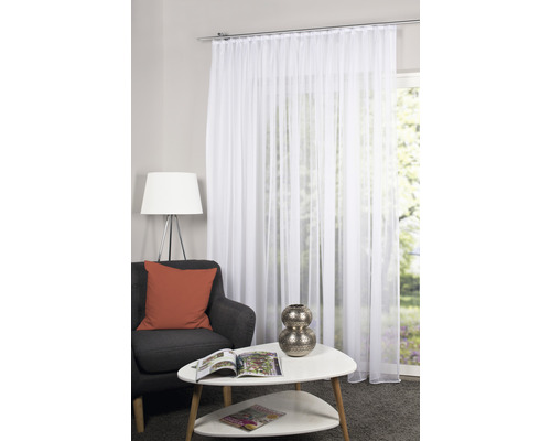Wohnzimmer mit weissem, transparentem Gardinenschal vor einem Fenster