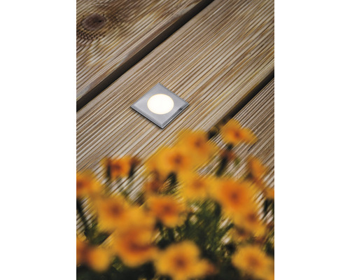 Spot encastrable au sol sur terrasse en bois avec fleurs au premier plan